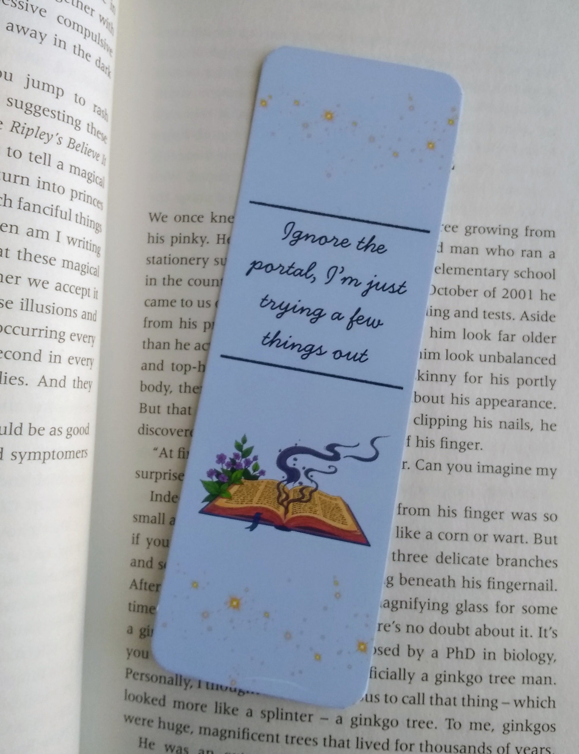 Bookmark with text 'Ignore the portal, I'm just trying a few things out' and illustration of a spell book on an open book