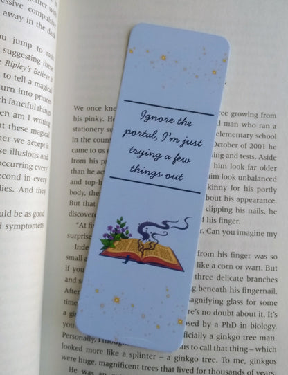 Bookmark with text 'Ignore the portal, I'm just trying a few things out' and illustration of a spell book on an open book