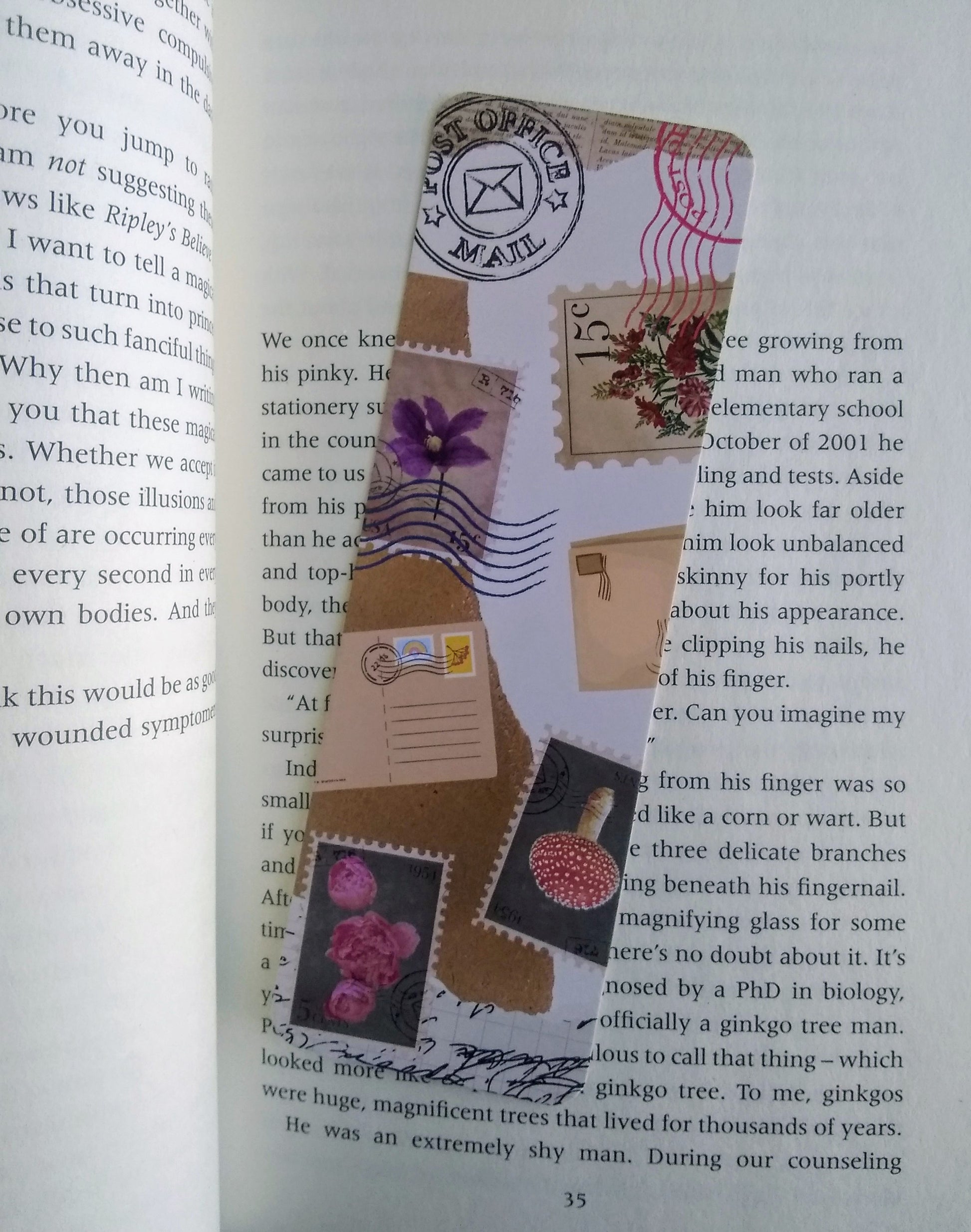 Decorative bookmark with postal-themed design on an open book