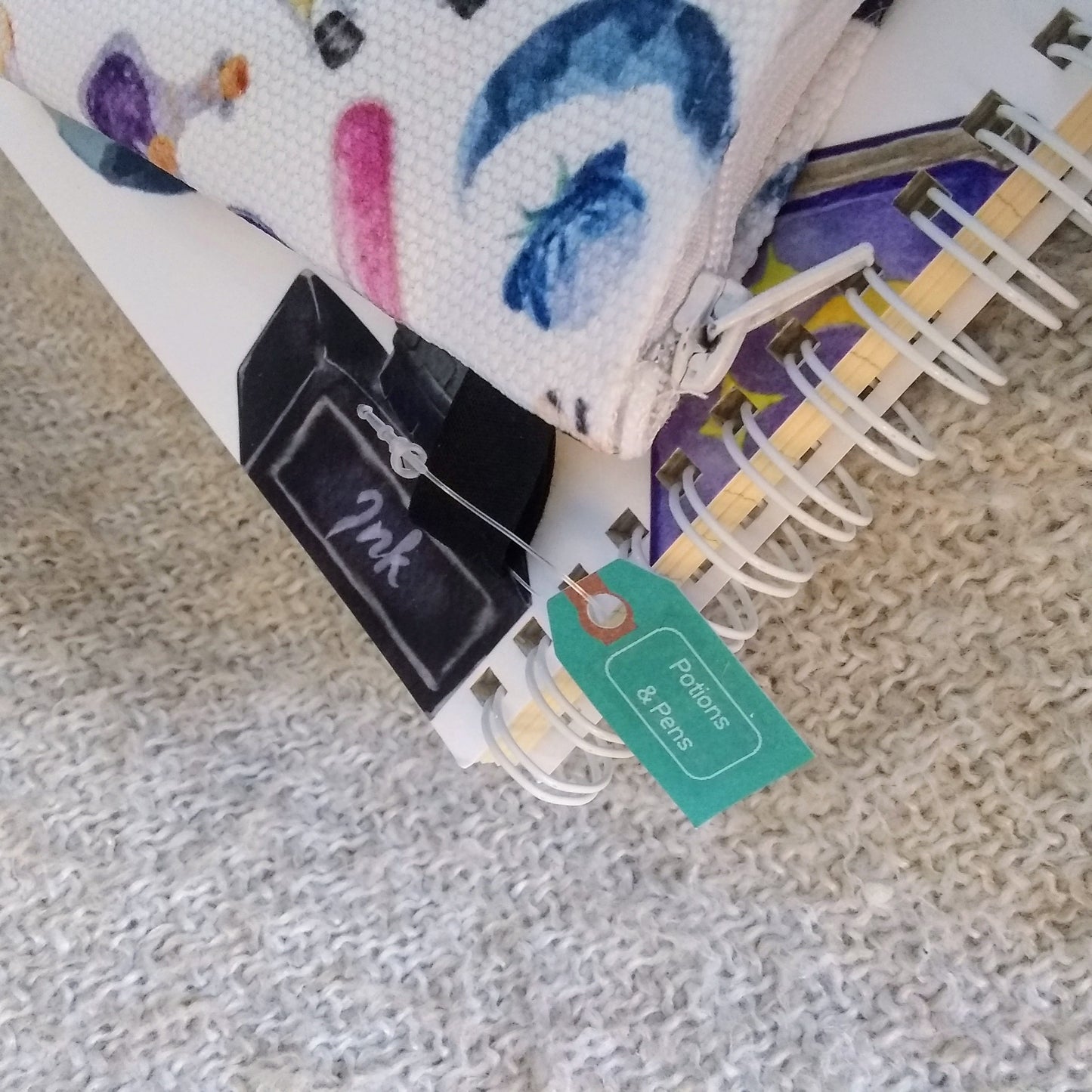 Colorful fabric pouch with tags on a textured surface