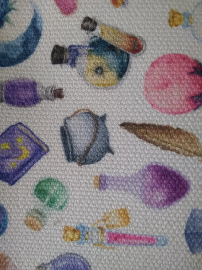Colorful fabric pattern with various items including bottles and a book.