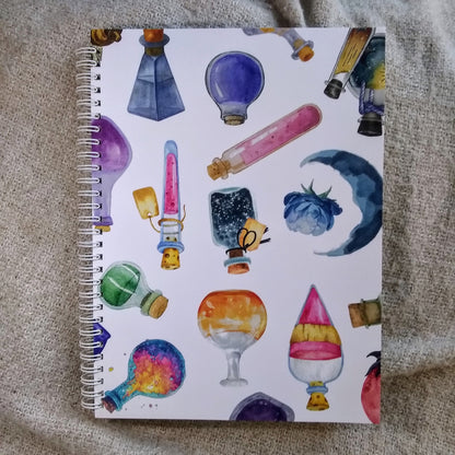 Notebook with colorful potion bottle illustrations on a textured surface