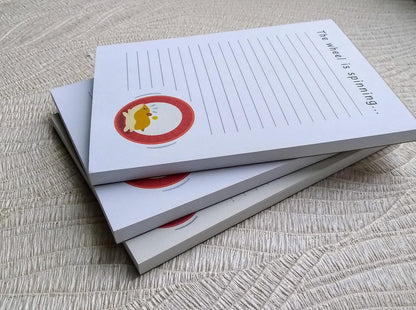 Picture of 3 notepads on top of each other viewed from the side.